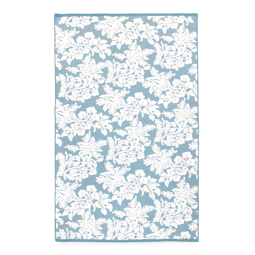A John Robshaw embroidered blue and white floral rug on a white background.