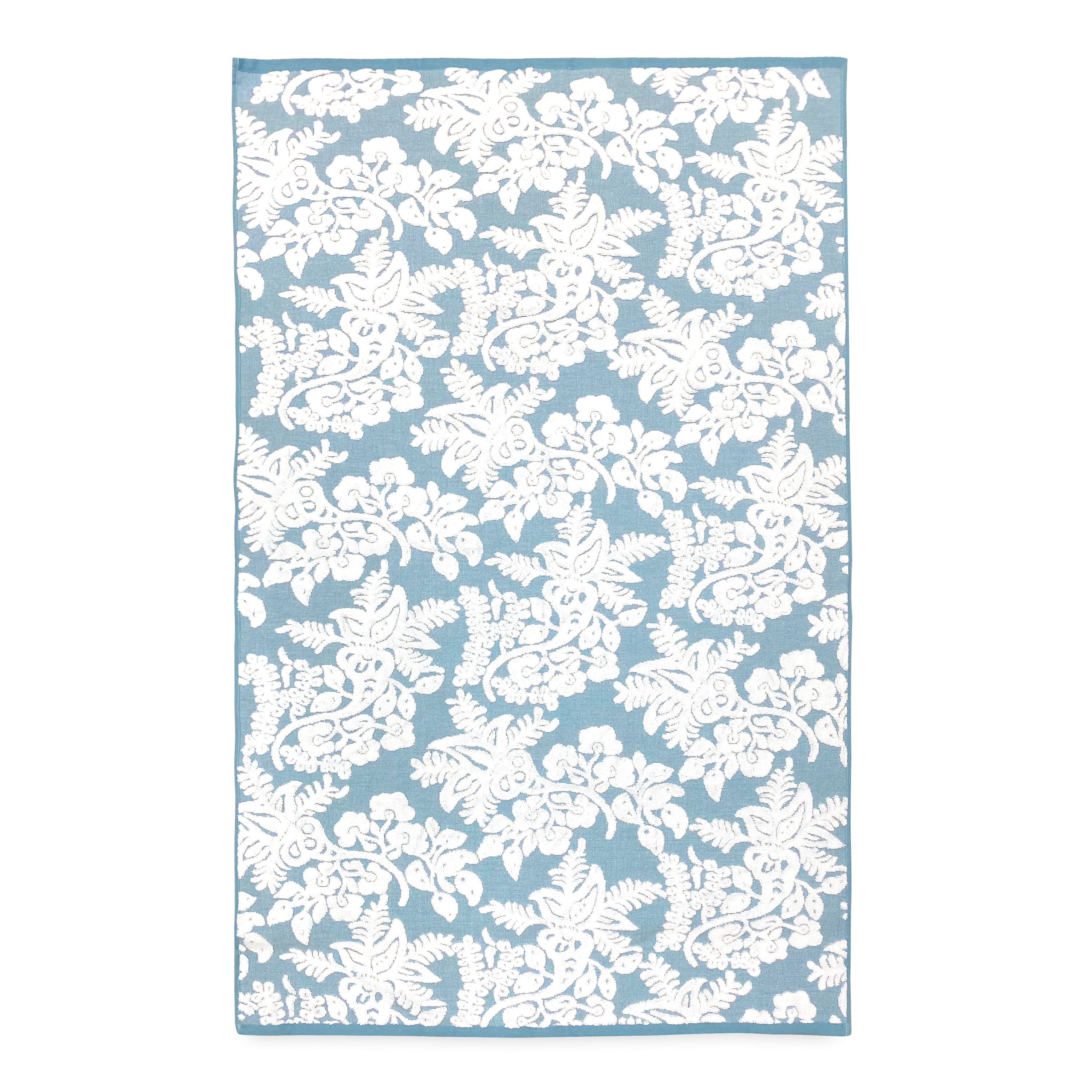 A John Robshaw embroidered blue and white floral rug on a white background.
