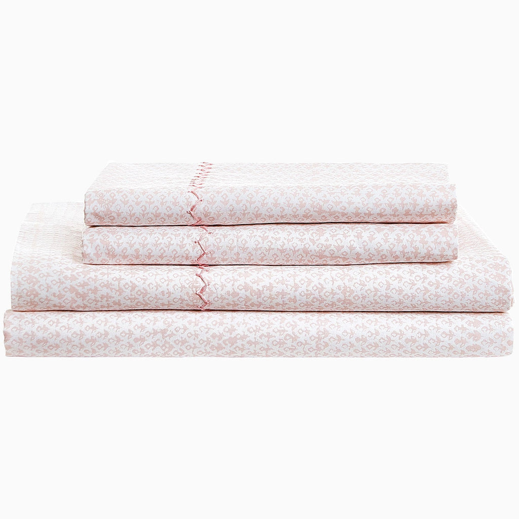 A stack of Poseti Lotus Organic Sheet Set by John Robshaw pink sheets.